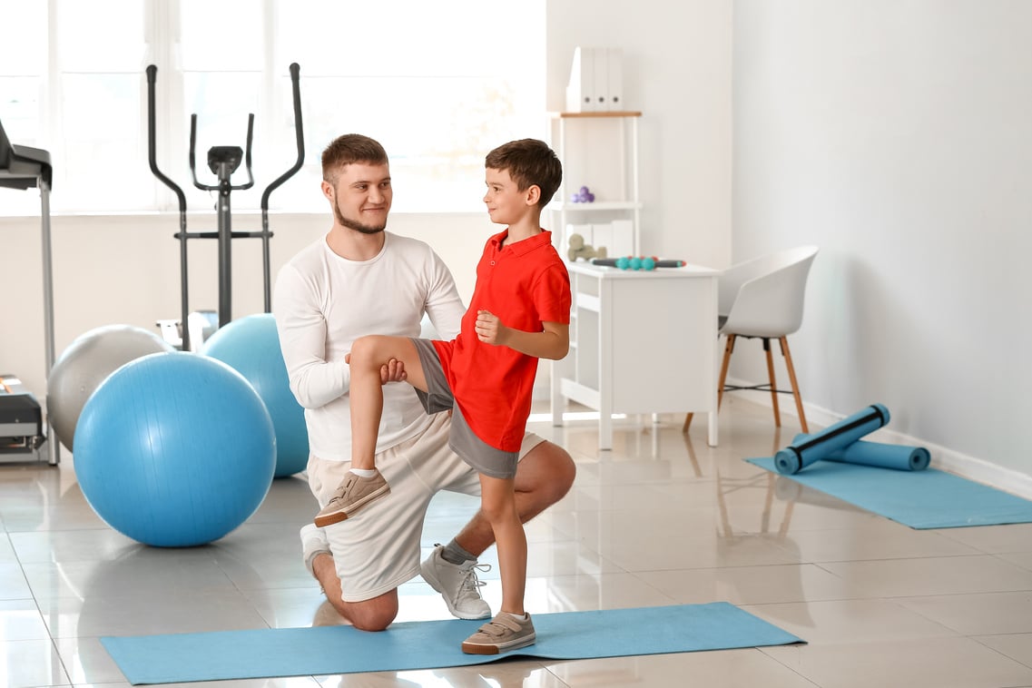 Physiotherapist Working with Boy in Rehabilitation Center